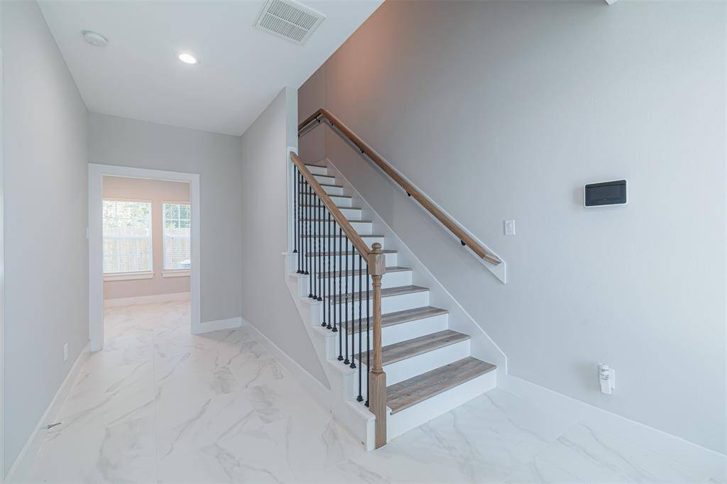 As you step through the front door, you're greeted by a welcoming hallway that leads to a private first-floor bedroom.