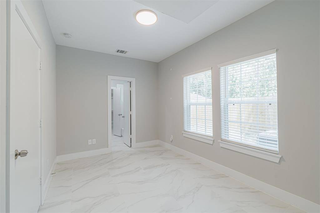 Private first-floor bedroom, complete with an ensuite bath and walk-in closet, ideal for guests or as a home office.