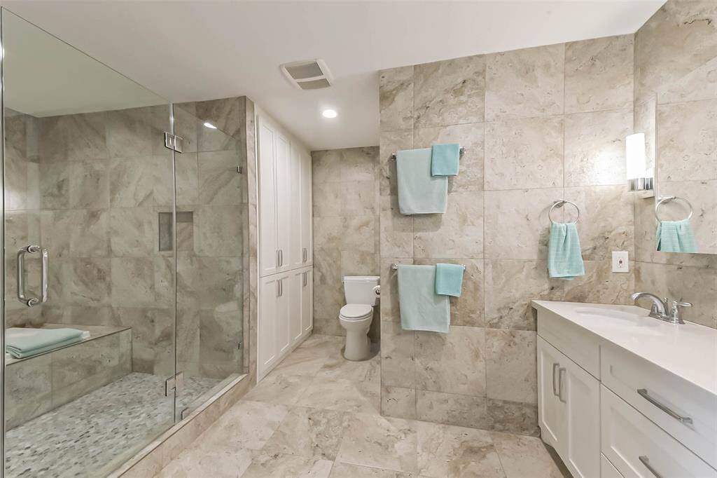 The primary bathroom gives you an idea of the scope of the remodeling. No costs have been spared. The enlarged primary bathroom is simply a dream, a place to unwind and recharge your batteries. Porcelain tiles,seamlessly covering walls and floor, sophisticated lighting and a sound system create a timeless elegance.