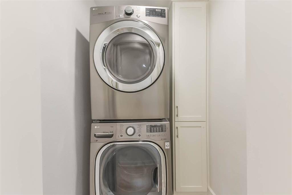The utility room is tucked away behind doors in the hallway and has built-in storage. Washer and dryer will be conveyed with the property.