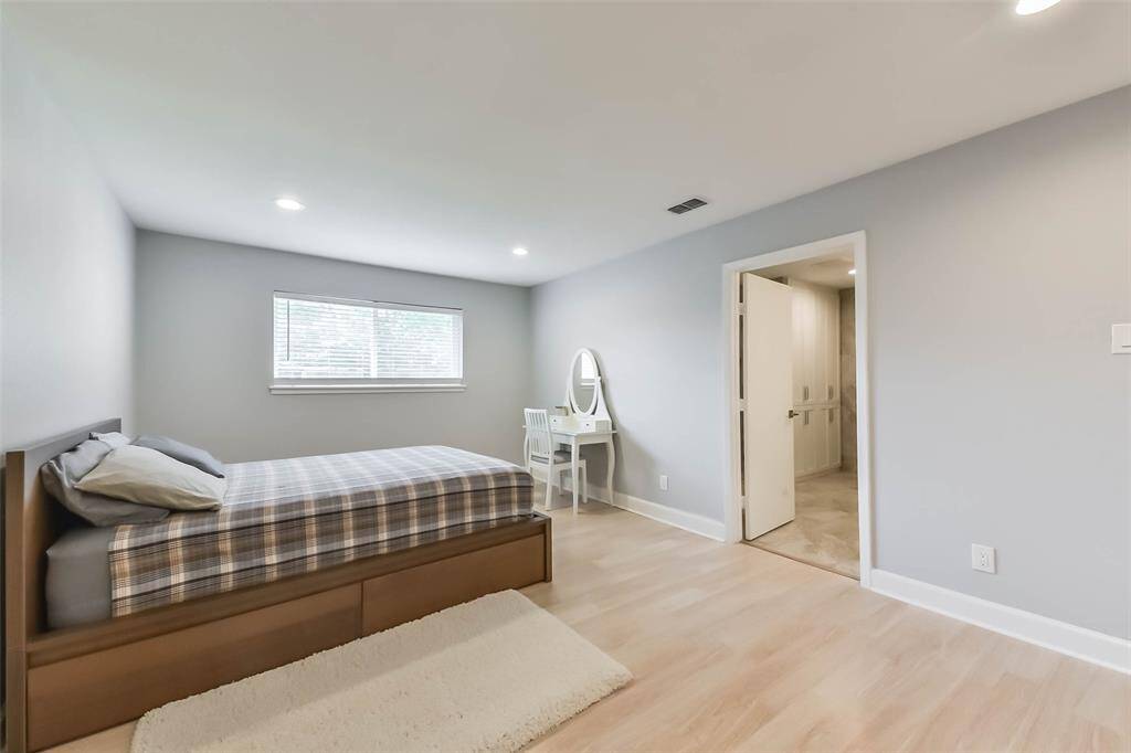 The walls, painted in an elegant light gray color, are accentuated with white boards and door frames.The door opens to the ensuite bathroom.