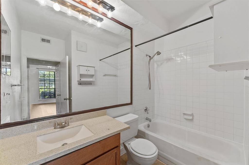 Fresh and clean bathroom with a large vanity, extra storage, and classic white tile finishes.
