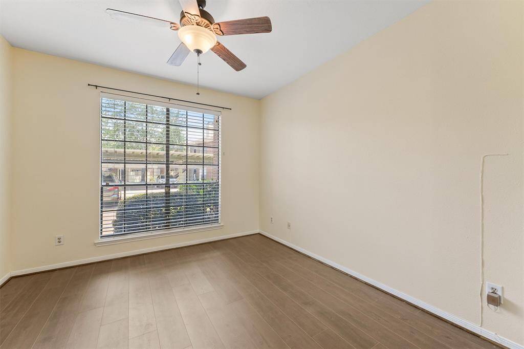 Bright and spacious bedroom featuring rich floors and a large window for natural light.