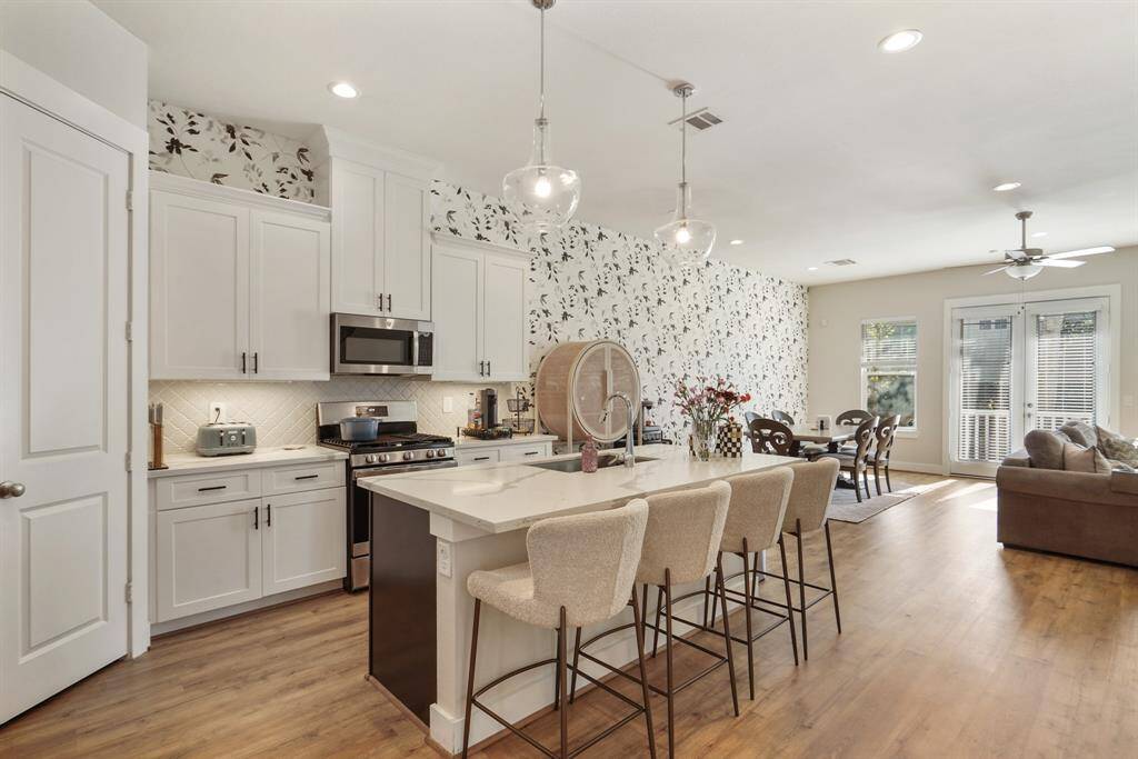 Light and bright kitchen with quartz countertops and gorgeous wallpaper that flows into the dining and living room