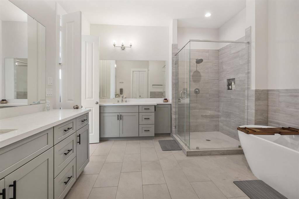 En-suite oasis in the Owner's Suite with plenty of counter space, seamless shower and modern soaking tub