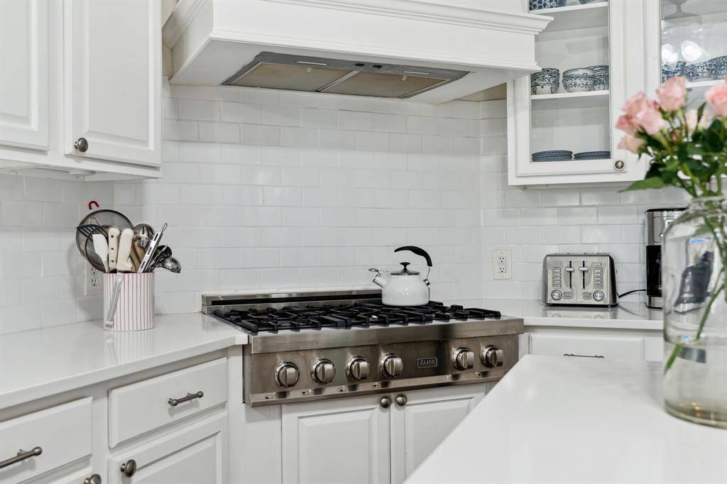The kitchen features white cabinets,creating a clean and timelessaesthetic.