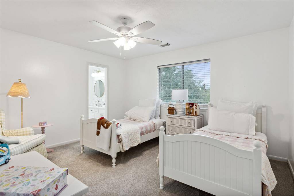 Third bedroom features awindow, ceiling fan, plush carpet, and en-suite bathroom.