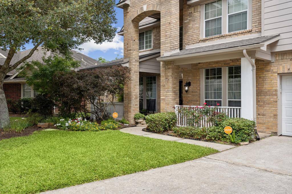 Approaching the front door is the covered front porch, brick elevation, and lovely landscaping.