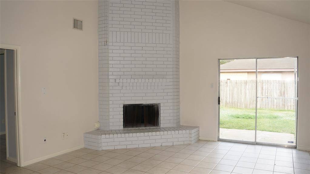 Large Family room with fire place with tiles throughout the house.