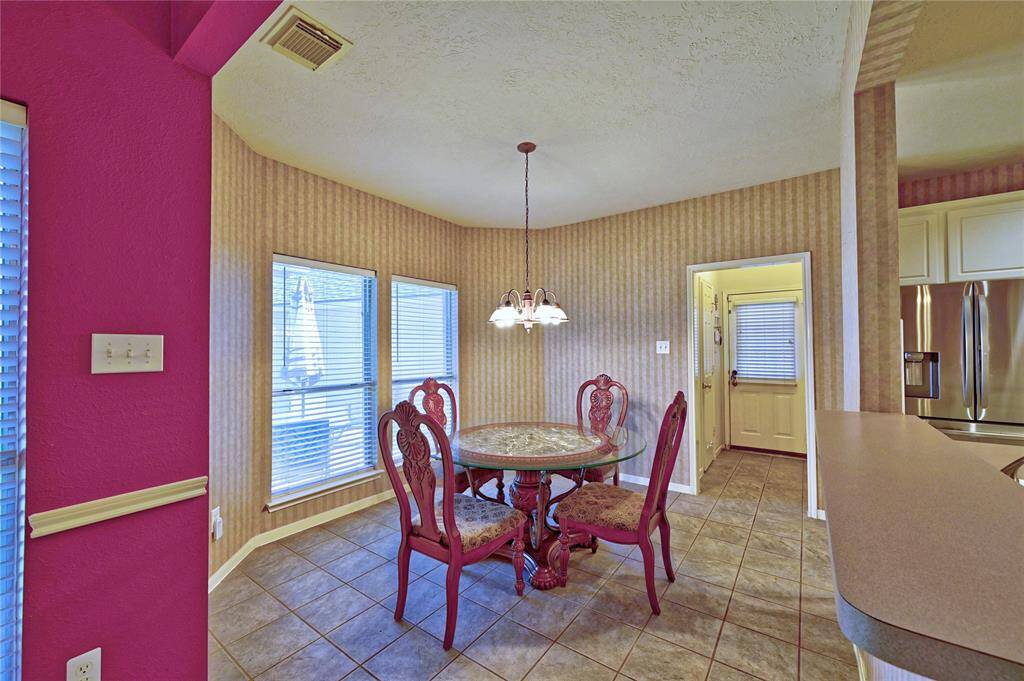 Cozy breakfast area with tiled flooring, view to living room.   Features ample natural light from two windows and connects to the kitchen and living room.