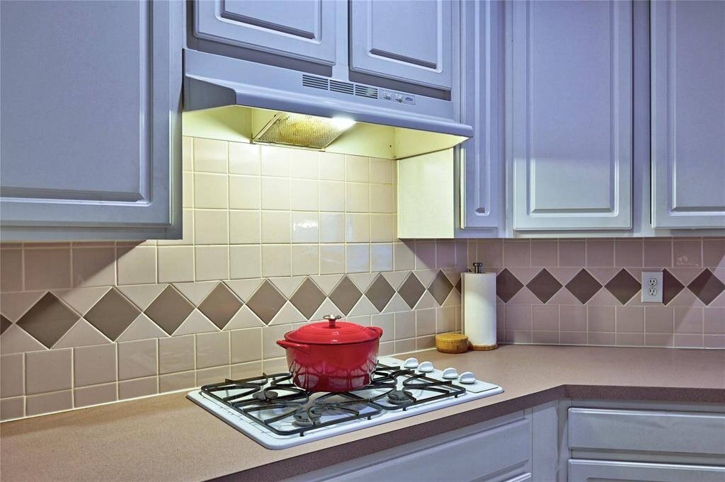 It includes a gas cooktop, under-cabinet lighting, and ample storage space.