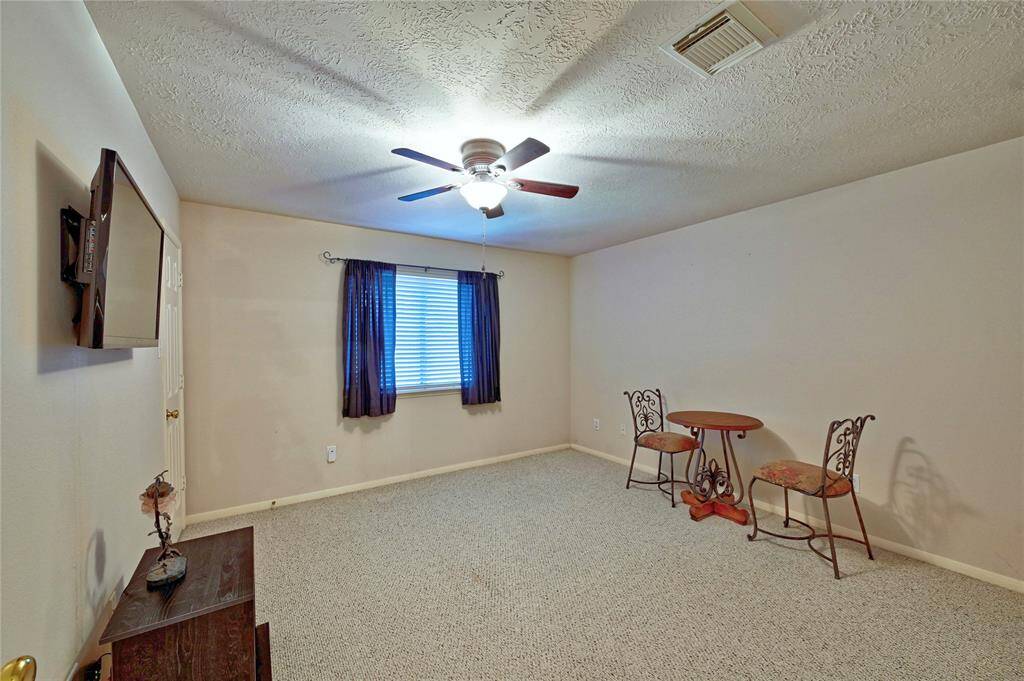 Bedroom 2 is spacious and carpeted, featuring a ceiling fan and a window with curtains. Walk in closet