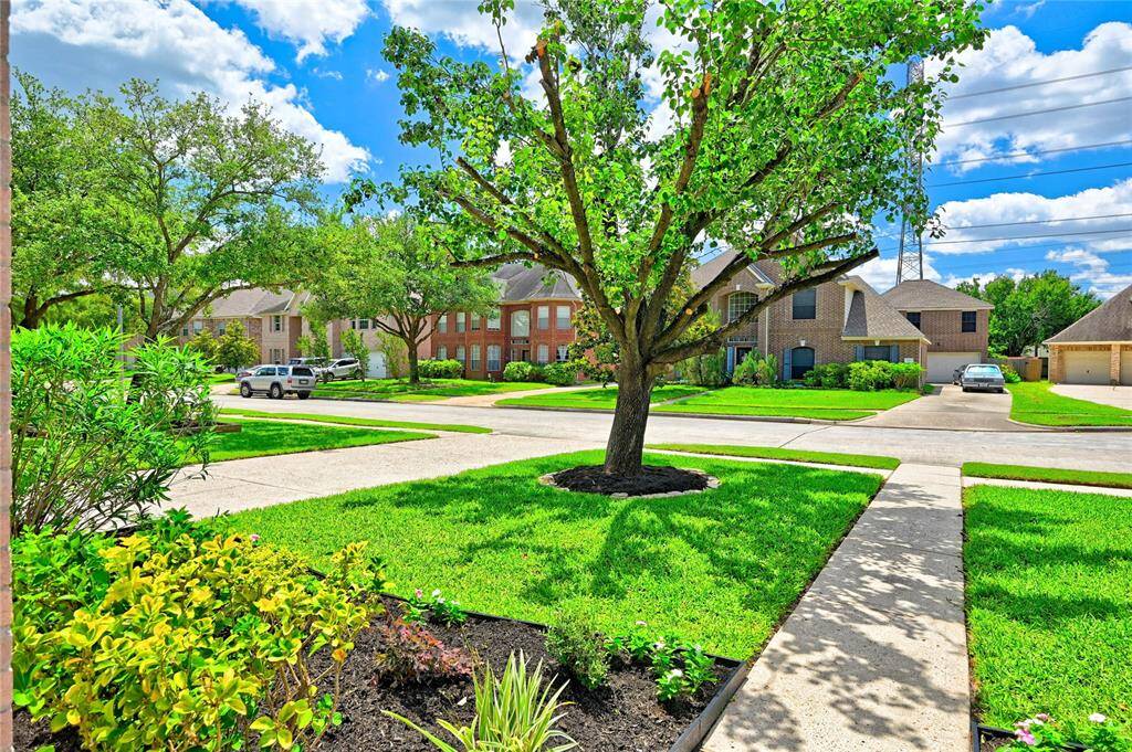Suburban home with well-maintained lawn and mature trees.