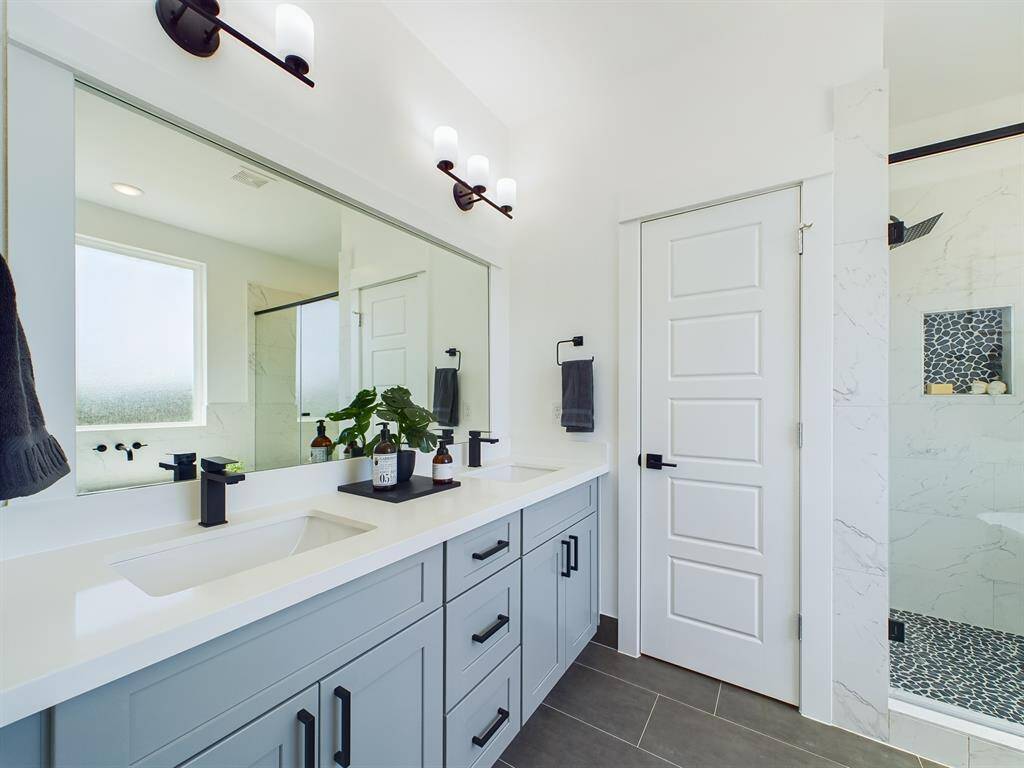 Primary Bathroom features a gorgeous freestanding tub and a separate shower with semi-frameless glass shower door. Photos from another development by Disama Construction. FINISHES & COLORS MAY VARY.