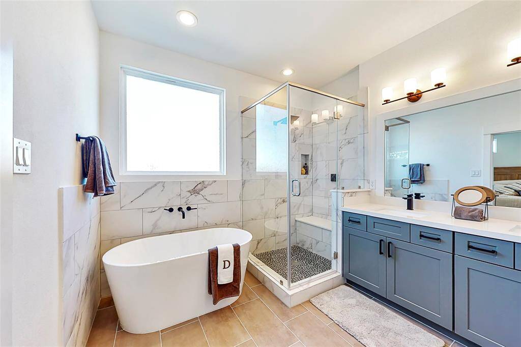 Primary Bathroom features a gorgeous freestanding tub and a separate shower with semi-frameless glass shower door. Photos from another development by Disama Construction. FINISHES & COLORS MAY VARY.