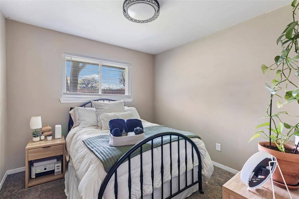 Bedroom with new carpet, lighting, and fresh neutral paint.