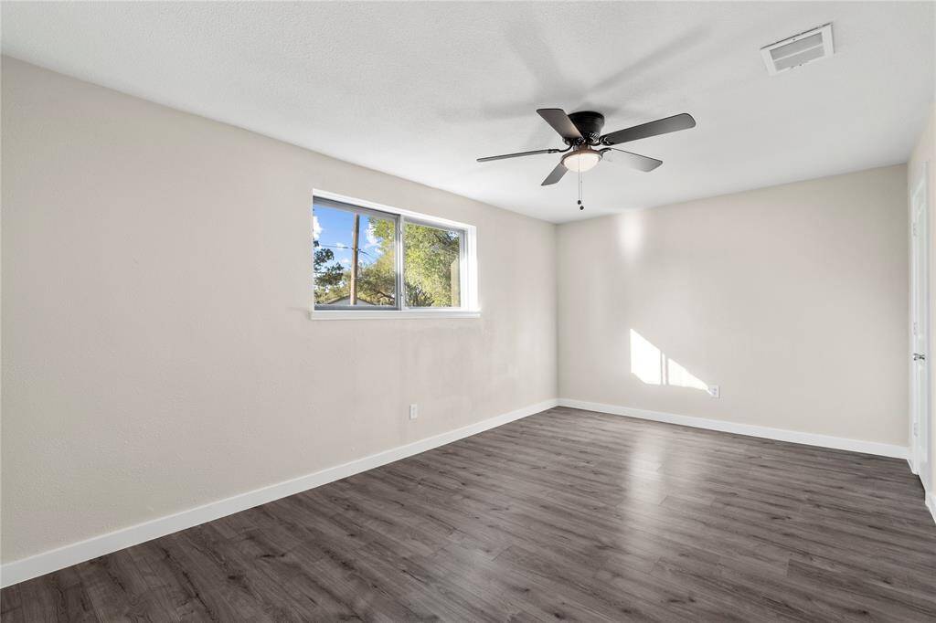 The final secondary bedroom, measuring 16x10 ft, offers ample space and natural light. Like all rooms in the home, it features a sleek new black modern ceiling fan, adding a touch of contemporary style.