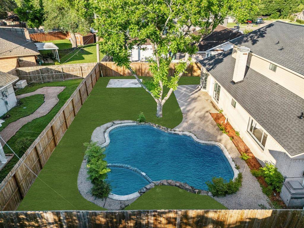 This backyard offers the perfect blend of relaxation and functionality. The pool area invites you to unwind, while the expansive grassy space provides plenty of room for outdoor activities.