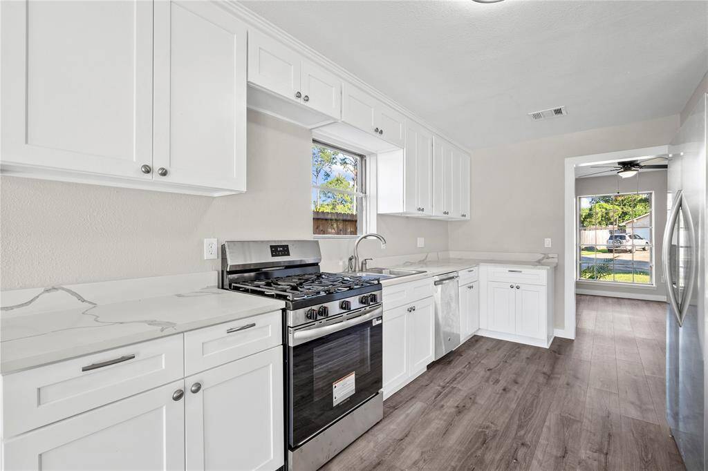 The kitchen has been fully updated with new cabinets, a quartz countertop, and brand-new appliances — including a stove and fridge — offering a fresh, functional space ready for daily use.