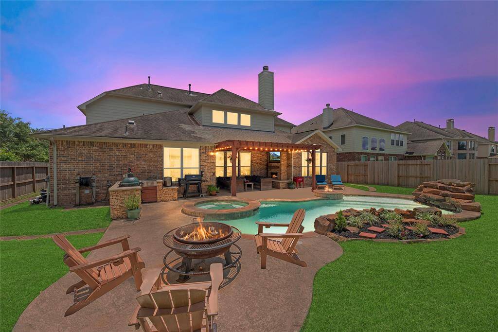 Enjoy resort-style living in this stunning backyard featuring a sparkling pool and relaxing spa. Entertain with ease under the covered patio complete with an outdoor kitchen, perfect for dining and gatherings year-round.
