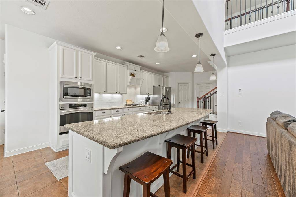 This beautifully updated kitchen, renovated in 2020, features timeless white cabinetry paired with a classic white subway tile backsplash for a clean, bright look. A custom range hood with a built-in shelf adds both style and functionality, while detailed island woodwork brings warmth and character to the space. The thoughtful updates create a fresh, inviting atmosphere perfect for everyday living and entertaining.