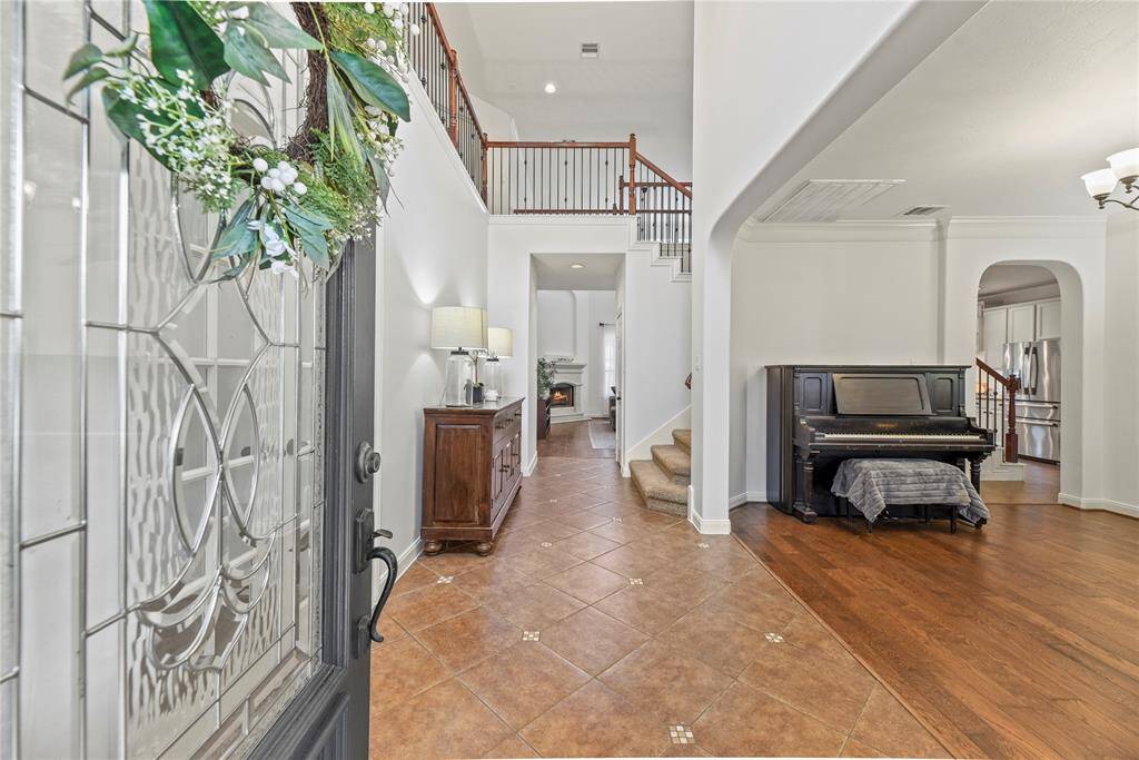 Entering the home, guests are met with durable tile flooring, which is accented with thick white baseboards and an attractive wood front door with sidelights.