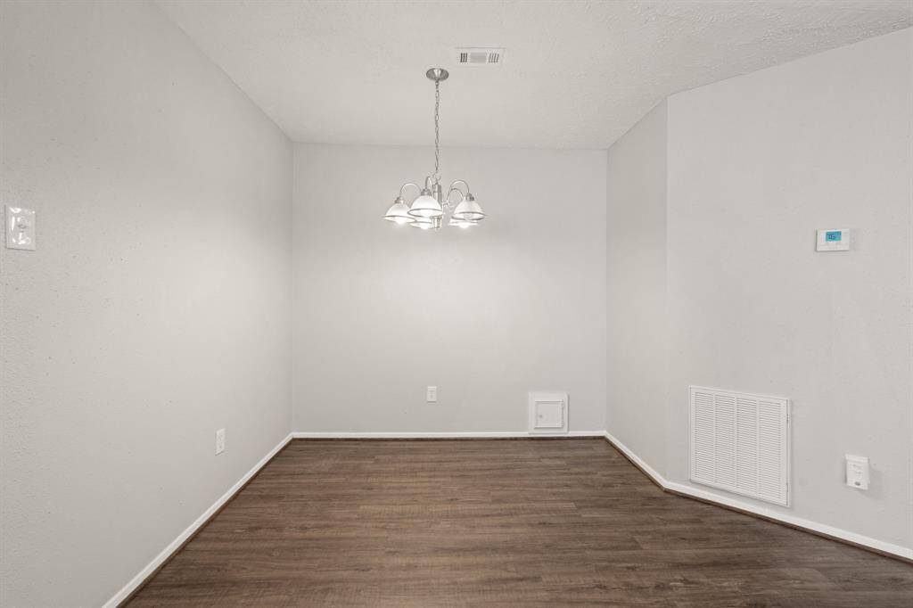 To the right, you'll find the dining area featuring a stylish chandelier and ample space to accommodate a large table—perfect for hosting family gatherings or dinner parties in comfort and style.