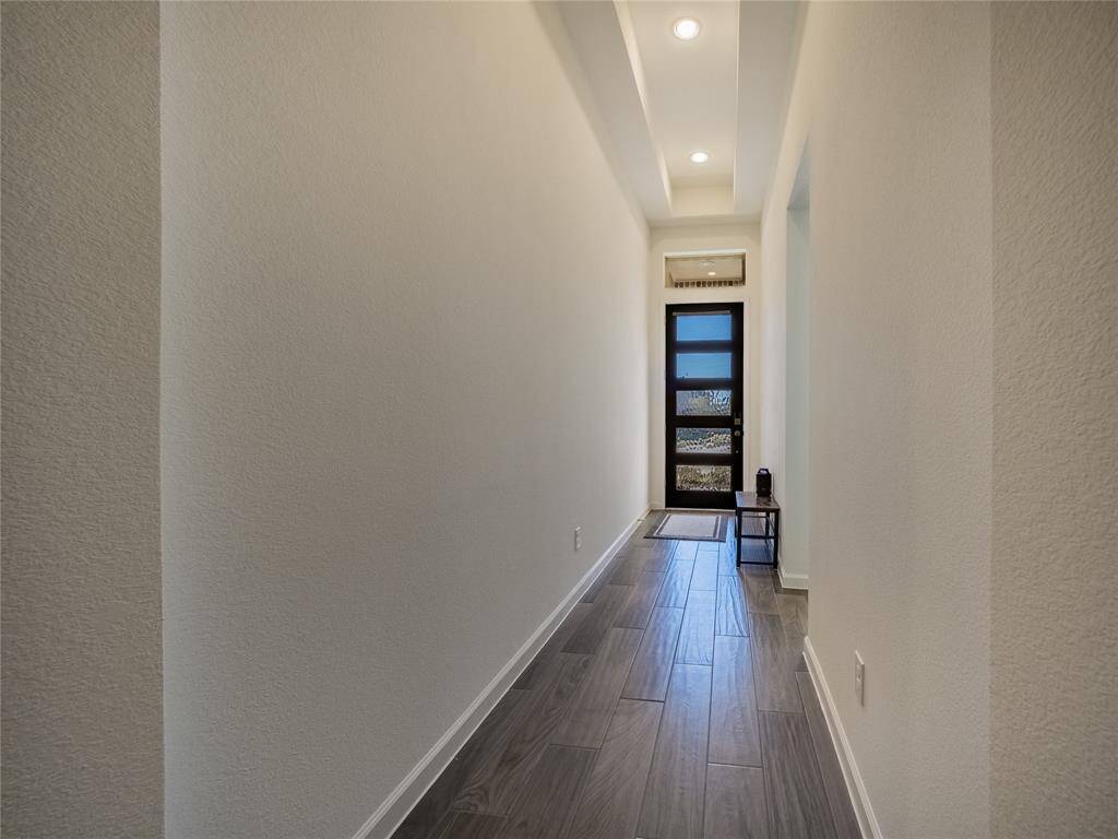 As you enter your new home you are greeted with these beautiful tile floors, outstanding front door and recessed lighting in the entrance hall, on your left is the guest suite with private bath