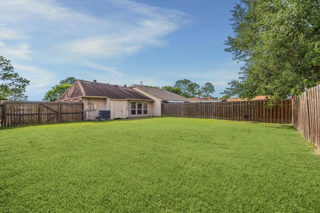 Spacious fenced backyard with a lush lawn, perfect for entertaining and outdoor fun.