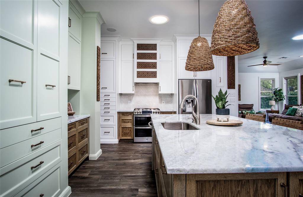 Custom Kitchen with all you need & MORE! So many details: stunning, natural stone, oversized island. Large, designer pendant lighting for both task lighting or ambiance. Custom, quality built cabinetry galore. Wire-bottomed produce drawers, pull-out pantry storage cabinets, Built in spice and bottle storage, paper towel drawer, charging drawers on both sides of the island. Rubber-coated drying drawer for dishes. Solar tubes for natural light. Custom, carved-wood inlaid vent hood. A true dream!