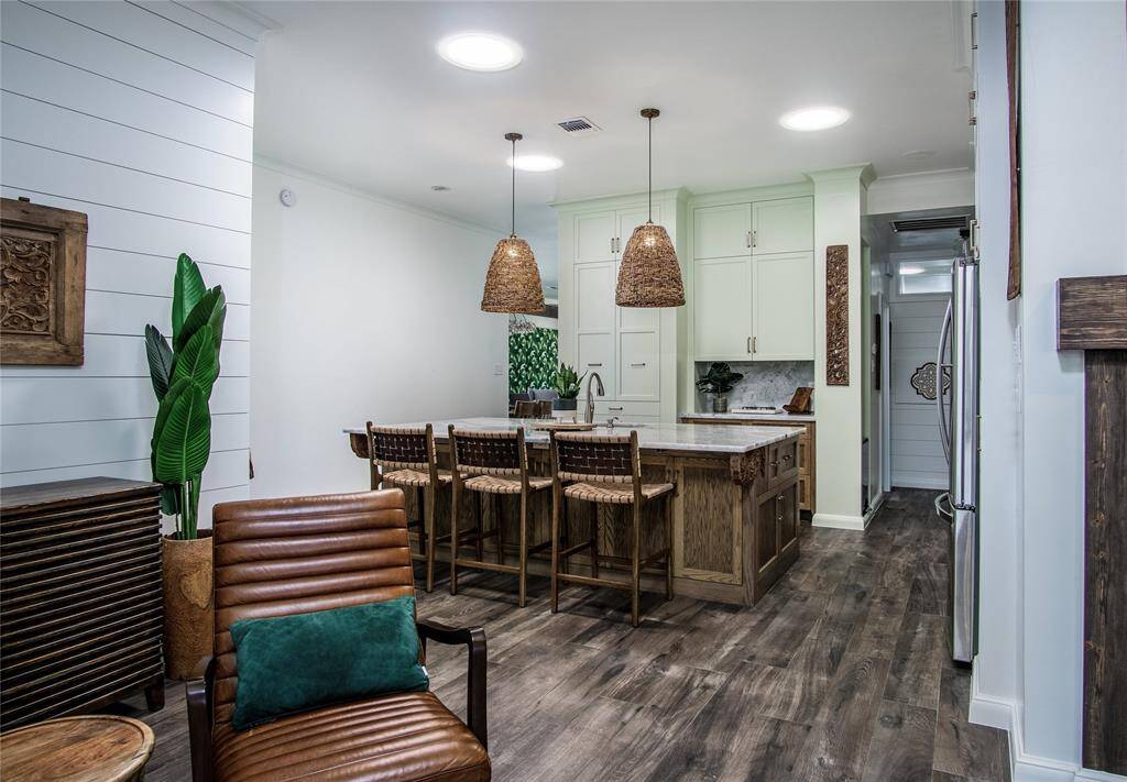 Magnificent kitchen in the center of the home with natural light from 3 large solar tubes, Grand natural stone island with custom wood cabinetry & carved wood accents also provides great seating space. Amazing flow in this floor plan!