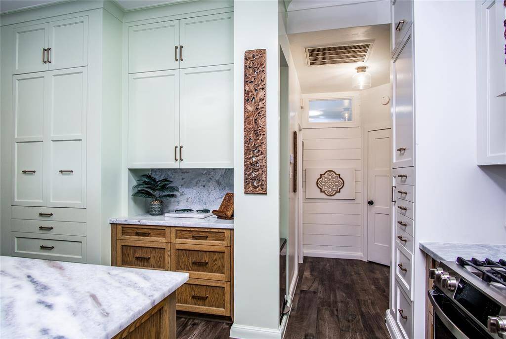 The abundance of stunning custom-built cabinetry keeps the home beautiful since everything has a place due to the thoughtful design elements. Through the kitchen is access to the 2 secondary bedrooms on the main floor as well as the 2nd full bath.