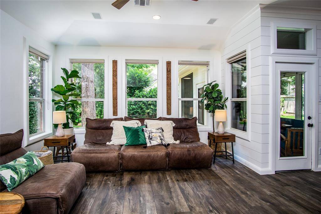 The wall of windows in the living room provide lots of light & lush views out to the nicely landscaped exterior.