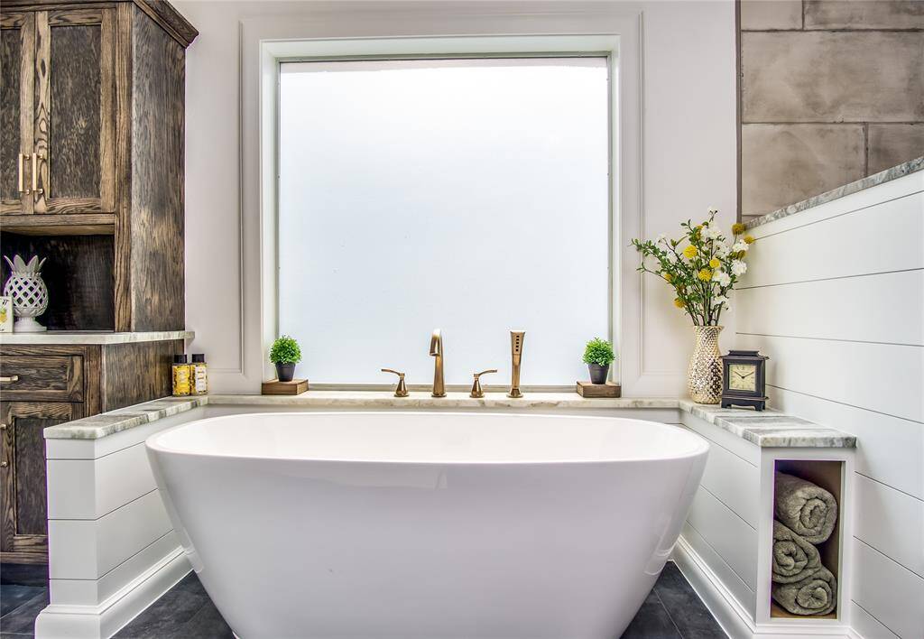 This soaking tub is very large, long, & deep! Leathered granite shelf surrounds the tub. Custom cabinetry makes storing your towels beautiful & convenient. Large window lets the light pour in!