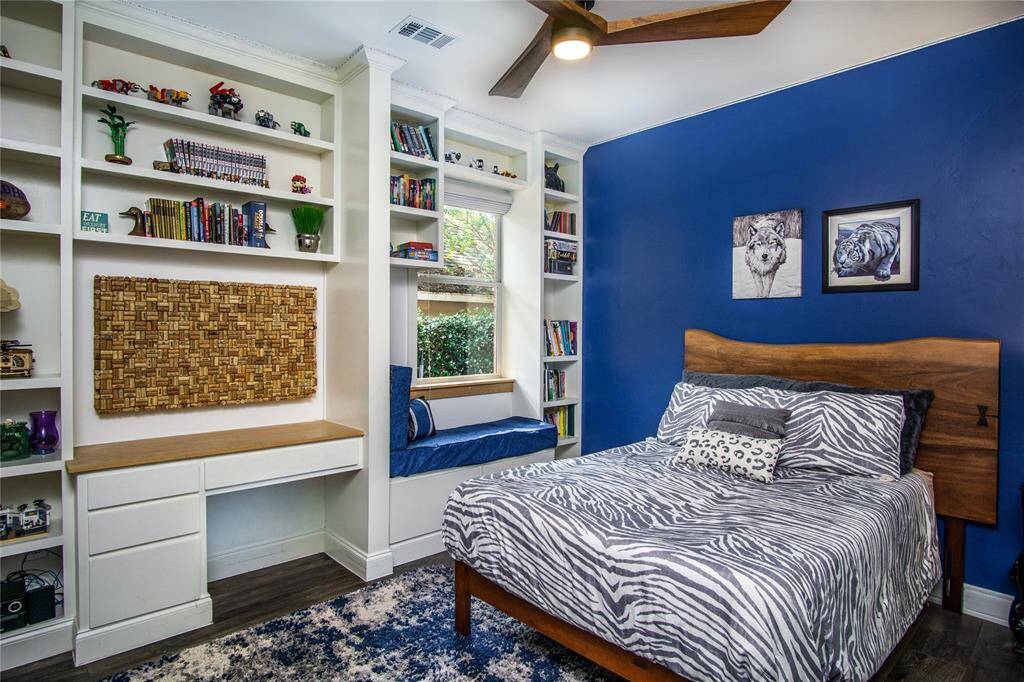 One of the secondary bedrooms on the main floor. This one features a wall of custom cabinetry, a built-in desk, & a window bench seat. Tile flooring continues into all the main floor bedrooms.