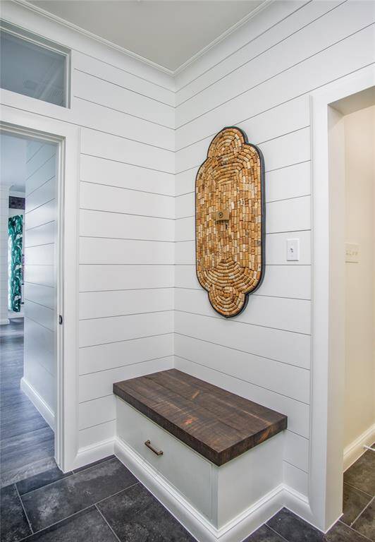 Seating bench with large drawer allows for storage of shoes & convenient spot to get ready to head out! Utility sink, stairs to the extra room, & garage access is on the right. The half bath & hall leading to the dining room is on the left.