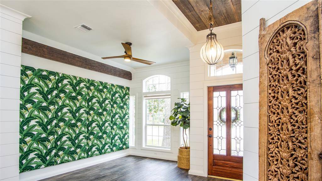 High ceilings throughout & an abundance of natural light. Exquisite wood touches added for depth & timeless, natural design. Tropical leaf patterned accent wall is not only gorgeous, but also has a hidden design feature. See the next photo!
