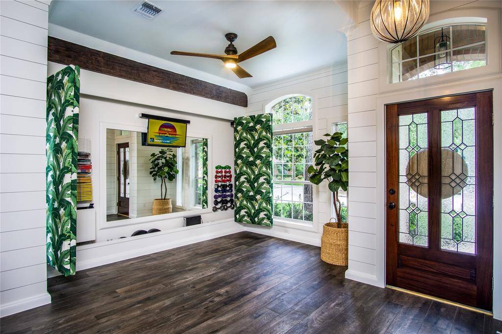 Surprise! Built-in & hidden wall for work out & audio/visual equipment. Just slide the paneled doors open to reveal a functional space with ceiling fan overhead to get your workout or relaxation session in. Large mirror on wall to check your form/posture. Then close it up to return to a peaceful & clean front room! You've never seen this before! So many custom design features that elevate your everyday lifestyle here!