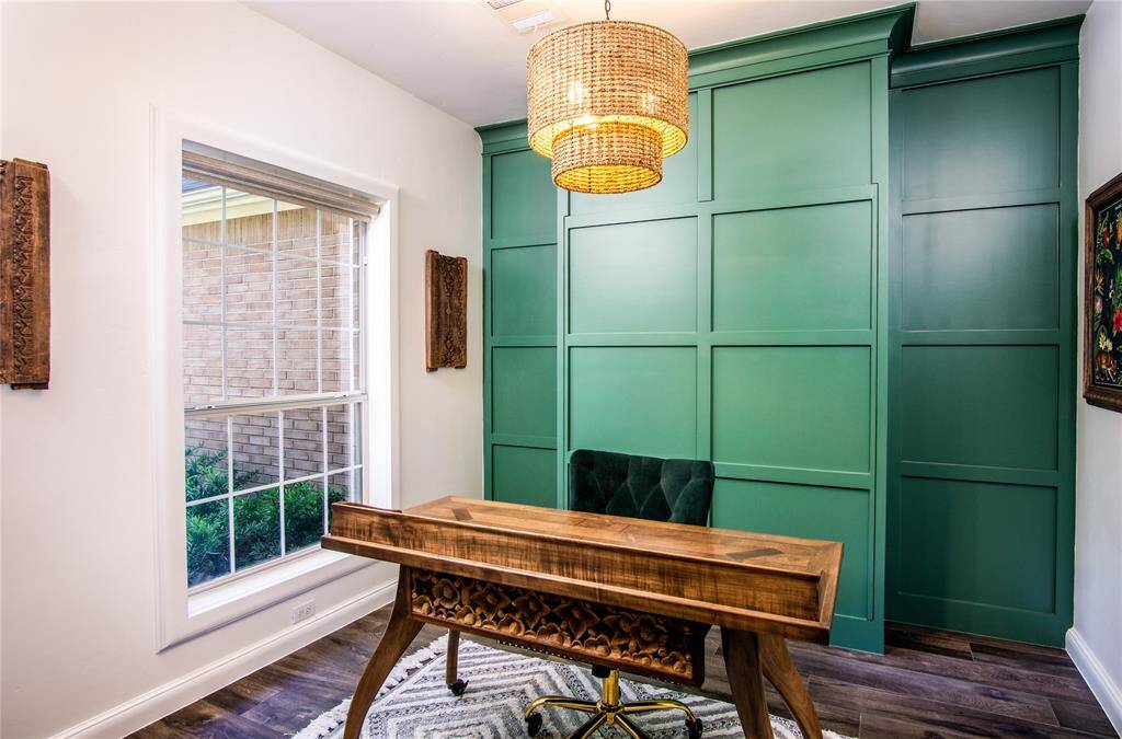 Surprise! The rich green accent wall is also a murphy bed for extra guests! The office has a magnificent view of the front from a large window.