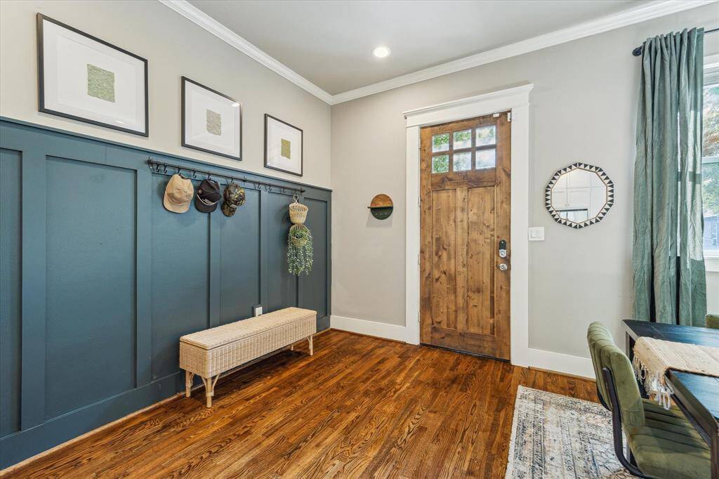 The entry way features custom molding and opens to the dining room and kitchen.