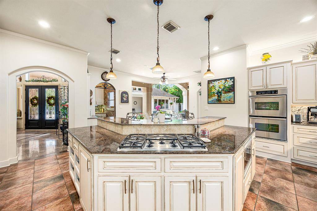 Island kitchen with a gas range and breakfast bar overlooking the breakfast area and pool