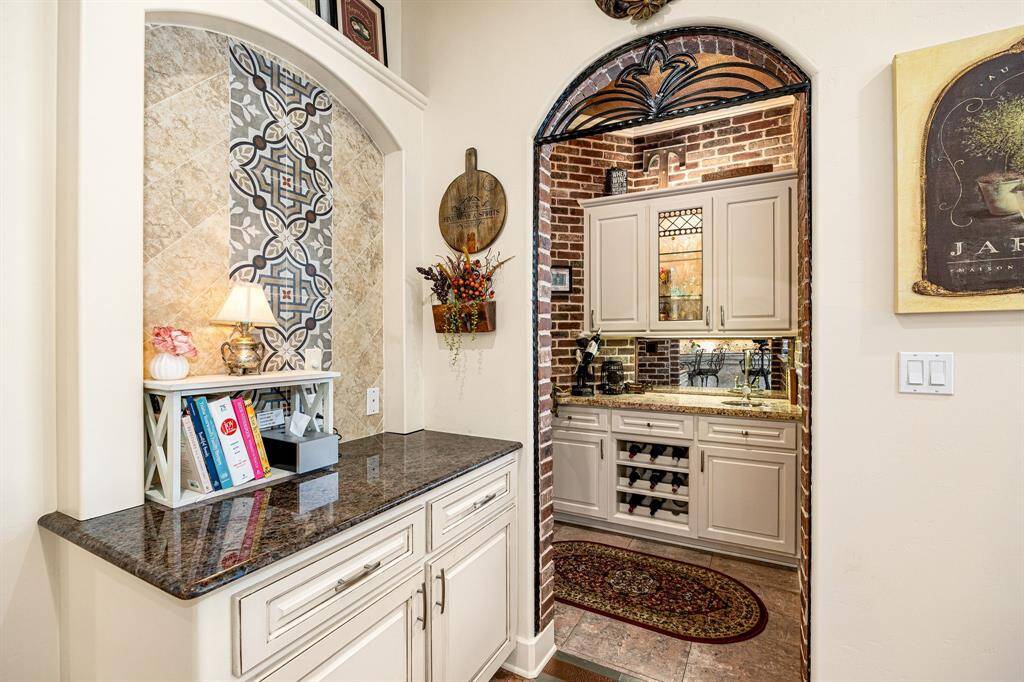 A charming coffee bar seamlessly transitions into a wine and wet bar area, framed by rich brick accent walls