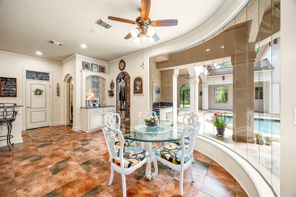 The breakfast sitting area is surrounded by elegant, curved windows offering serene views of the pool, filling the space with natural light and a peaceful ambiance to start your day.