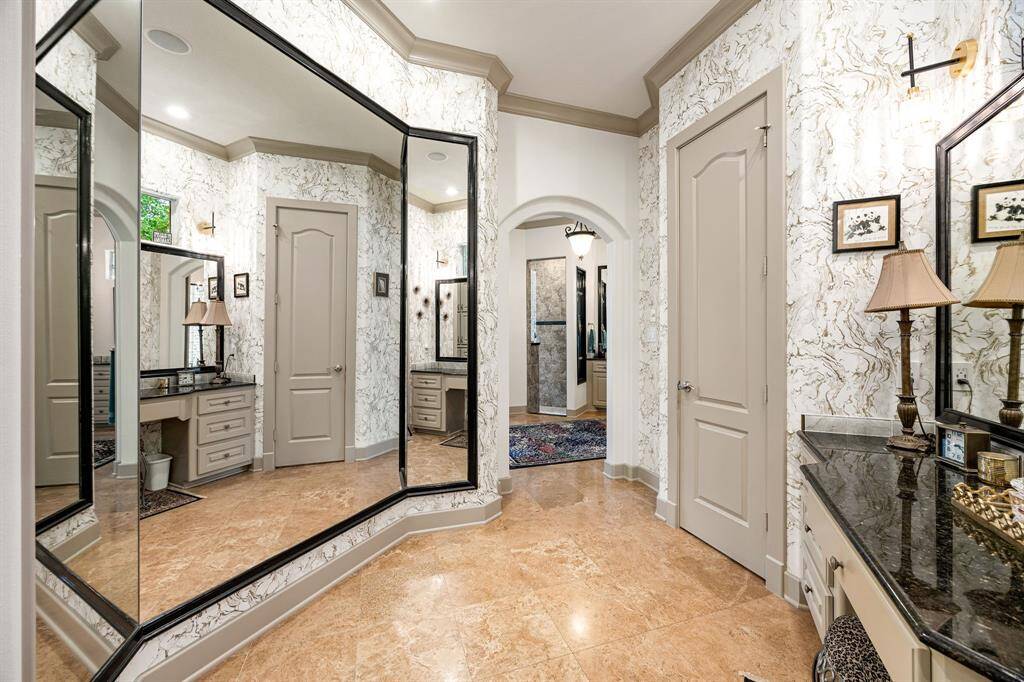 The primary bathroom is enhanced with nearly floor-to-ceiling dressing mirrors, adding a touch of glamour