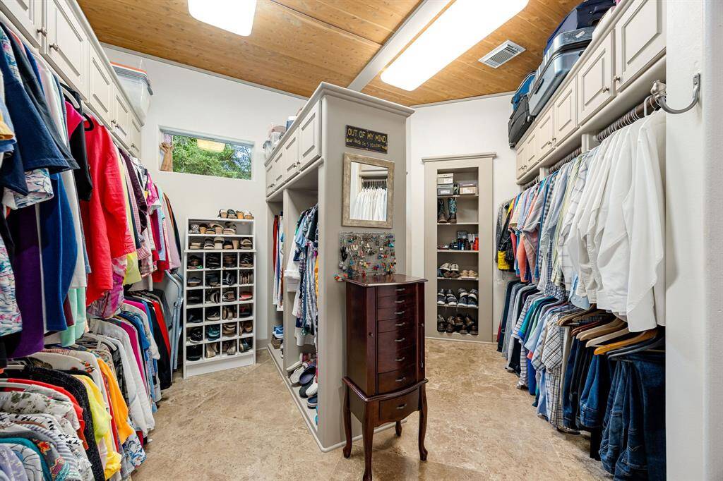 Primary walk-in closet with built in cabinets for extra storage. Behind the door is a hidden panel in the primary closet lies a secure, tucked-away storage area — ideal for heirlooms, keepsakes, or sensitive documents