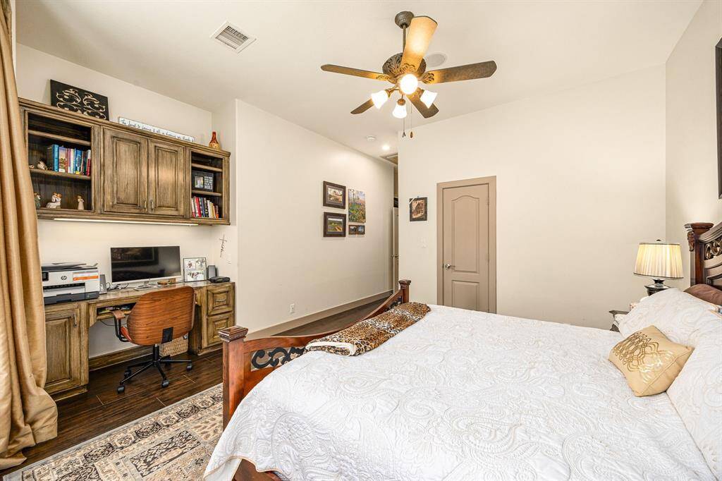 Secondary bedroom with a built-in work area and walk in closet