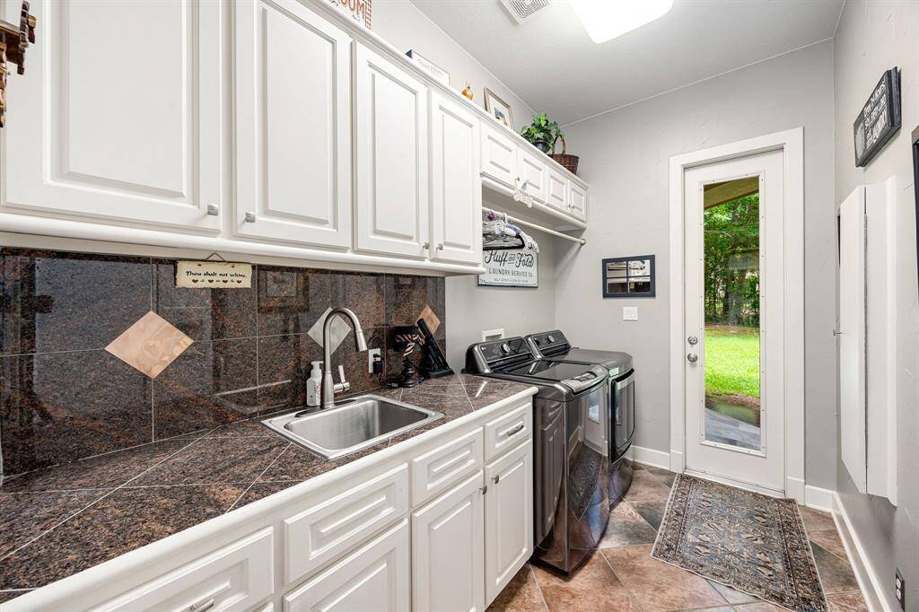 Laundry / MUD room with tons of storage, sink and access to the backyard