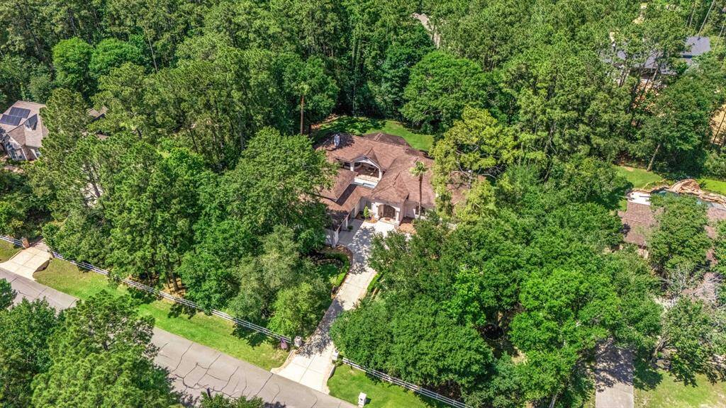 Aerial view of the home that is nestled on a little over 1-acre wooded lot