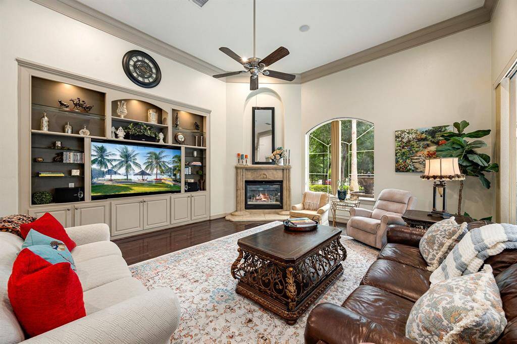 The family room offers built-in cabinets with glass shelving, a cozy gas fireplace, and a warm, inviting atmosphere