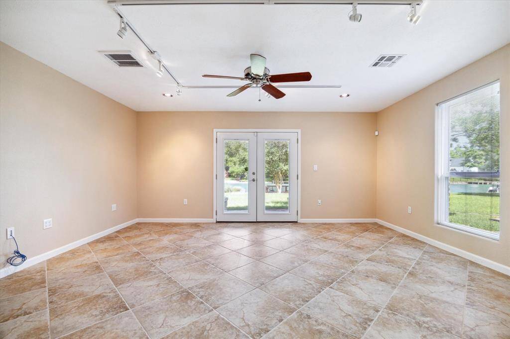 Flex room that could be used as a gameroom or a home office and is right off the garage, also with a view of the lake with French doors